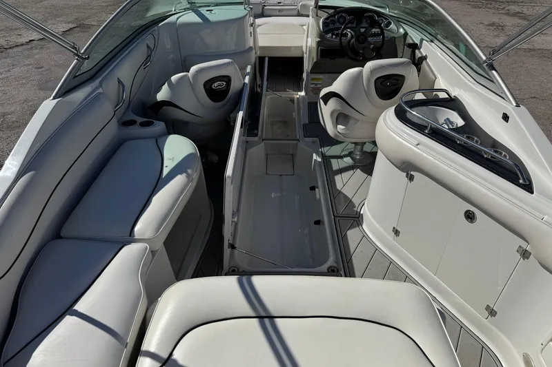 Slide: The Image of 2007 Crownline 240 EX boat interior with white seating and steering console. - 18
