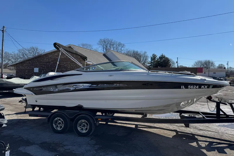 Slide: The Image of 2007 Crownline 240 EX boat on trailer, parked outdoors under clear blue sky. - 2