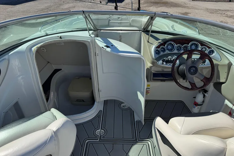 Slide: The Image of 2007 Crownline 240 EX boat interior with helm, seating, and cabin door open. - 20