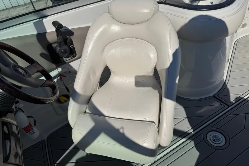 Slide: The Image of 2007 Crownline 240 EX boat interior with white captain's chair and steering wheel. - 25