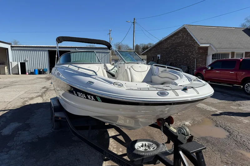 Slide: The Image of 2007 Crownline 240 EX boat on trailer, parked outdoors near buildings. - 8