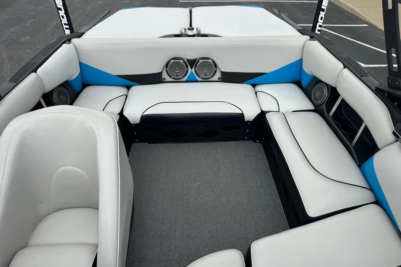 Slide: The Image of 2011 Axis A20 boat interior with white and blue seating, featuring built-in speakers. - 11