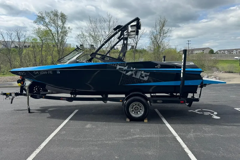 Slide: The Image of 2011 Axis A20 boat on trailer in parking lot, overcast sky. - 6