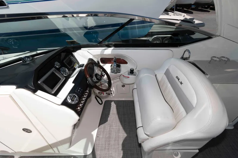 Slide: The Image of 2009 Sea Ray 300 SLX boat interior with white seating and modern dashboard controls. - 2