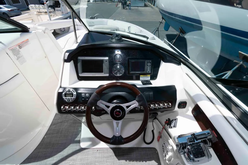 Slide: The Image of 2009 Sea Ray 300 SLX boat dashboard with steering wheel and navigation controls. - 4
