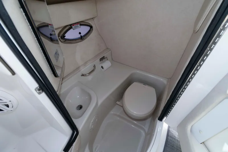 Slide: The Image of 2009 Sea Ray 300 SLX boat bathroom with toilet, sink, and porthole window. - 9