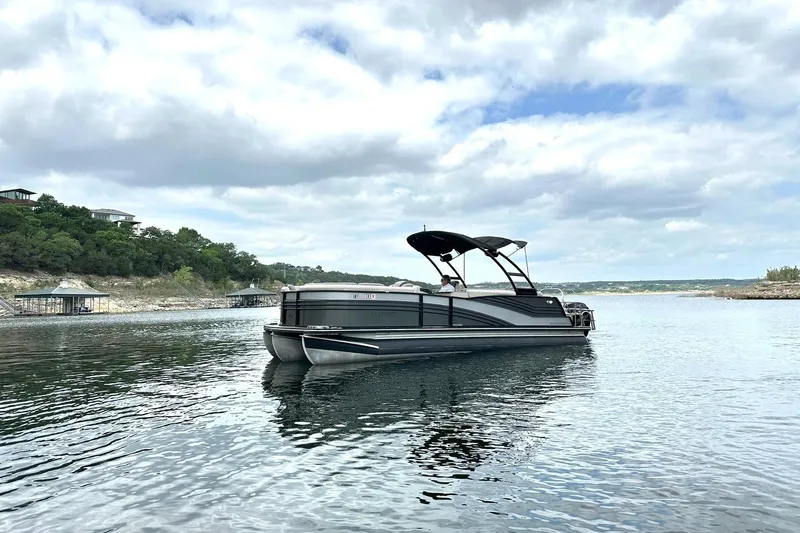 Slide: The Image of 2018 Harris Grand Mariner 250 pontoon boat on a serene lake under cloudy skies. - 10