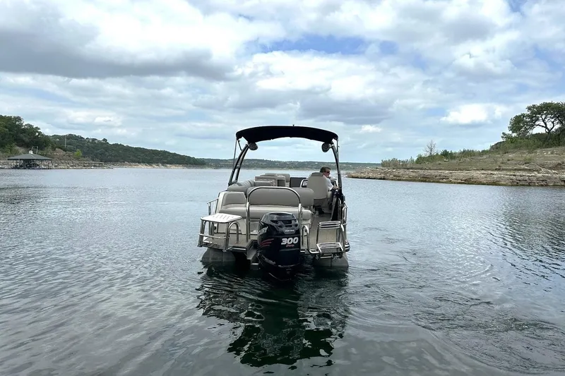 Slide: The Image of 2018 Harris Grand Mariner 250 pontoon boat cruising on a scenic lake. - 12