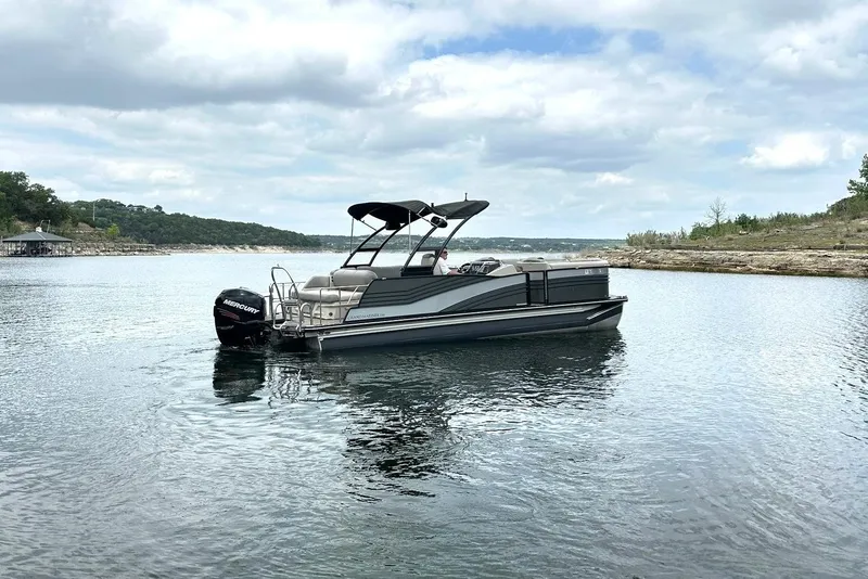 Slide: The Image of 2018 Harris Grand Mariner 250 pontoon boat on a serene lake under cloudy skies. - 13