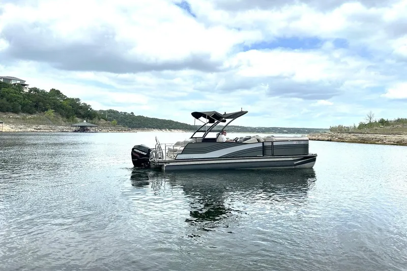 Slide: The Image of 2018 Harris Grand Mariner 250 pontoon boat on a serene lake under cloudy skies. - 14
