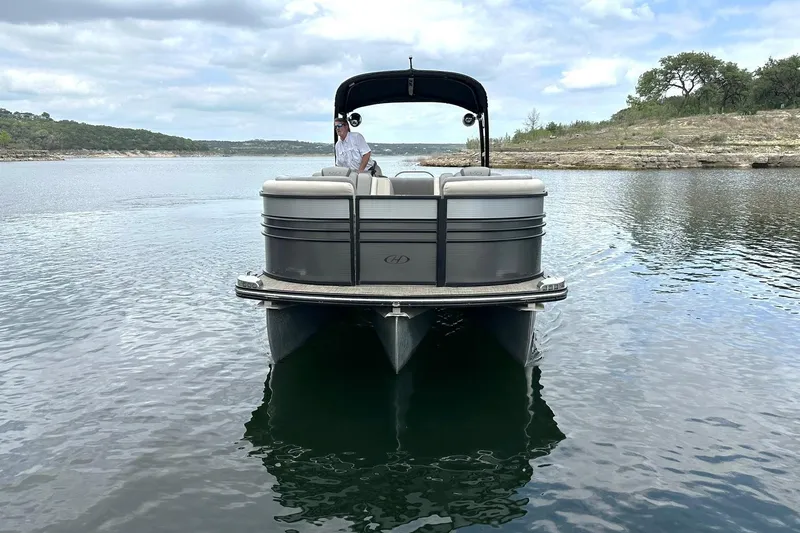 Slide: The Image of 2018 Harris Grand Mariner 250 pontoon boat on a serene lake with scenic background. - 15