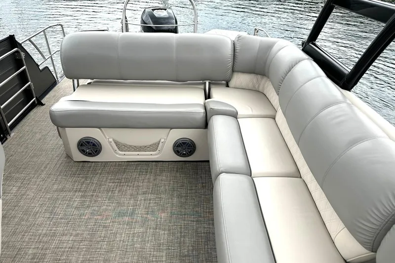 Slide: The Image of 2018 Harris Grand Mariner 250 boat with spacious gray seating and water backdrop. - 26