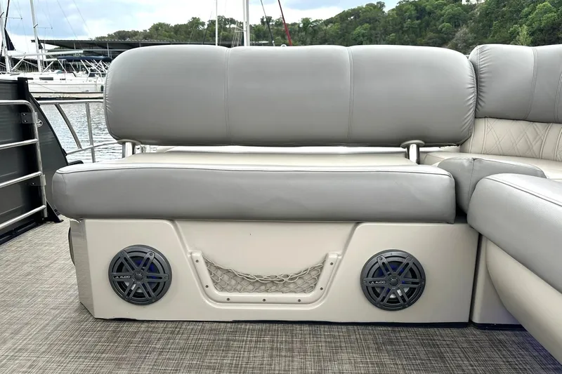Slide: The Image of 2018 Harris Grand Mariner 250 boat seating with speakers, docked by a marina. - 27