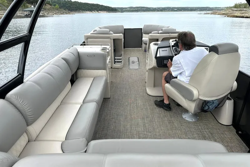 Slide: The Image of 2018 Harris Grand Mariner 250 pontoon boat interior with driver on a serene lake. - 32