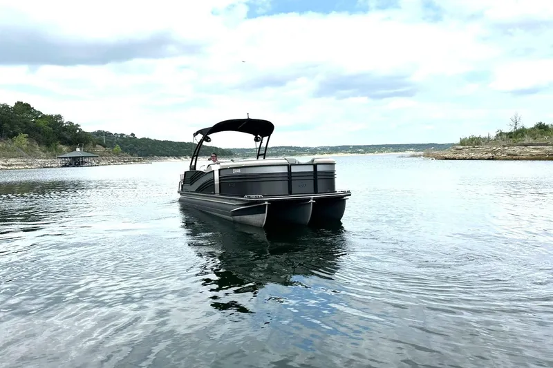 Slide: The Image of 2018 Harris Grand Mariner 250 pontoon boat cruising on a scenic lake. - 7