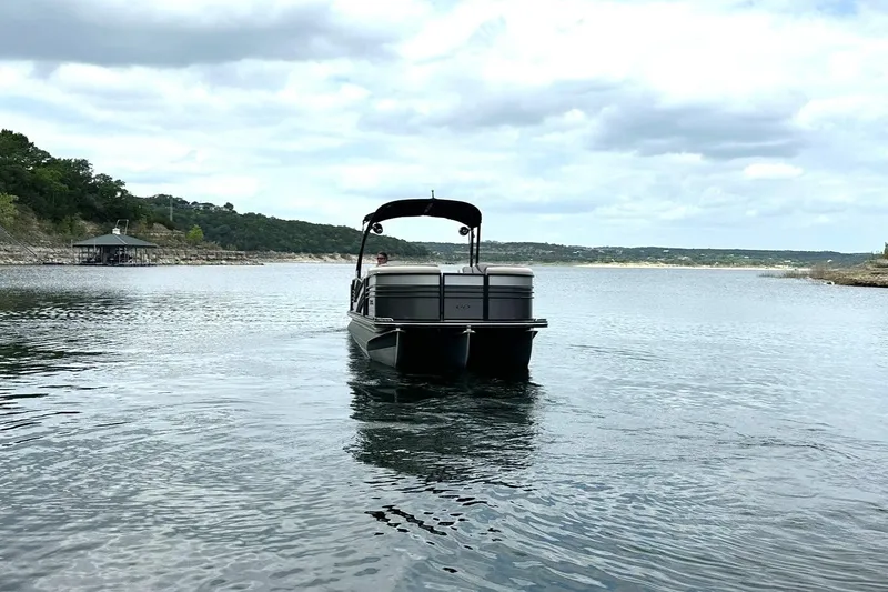 Slide: The Image of 2018 Harris Grand Mariner 250 pontoon boat cruising on a scenic lake. - 8