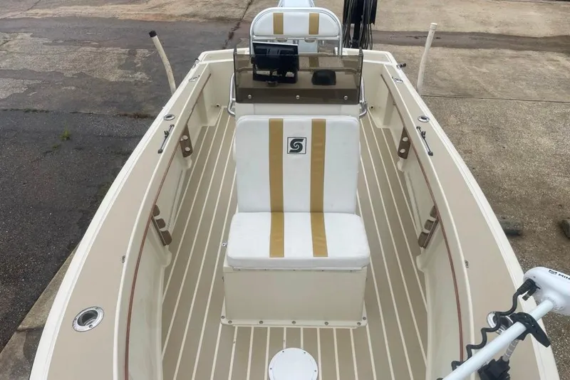 Slide: The Image of 1983 Sea Craft SF18 boat interior with white and beige seating, docked on concrete. - 18