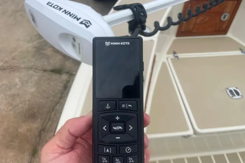 Slide: The Image of Hand holding Minn Kota remote on 1983 Sea Craft SF18 boat deck. - 23