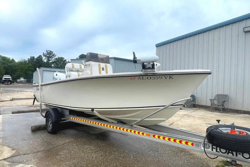 Slide: The Image of 1983 Sea Craft SF18 boat on trailer, parked near industrial building. - 5