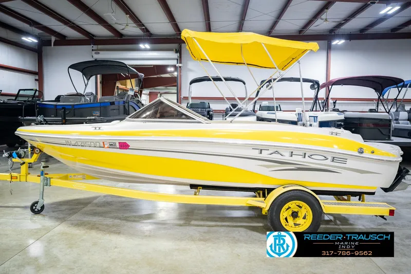 Slide: The Image of Yellow 2005 Tahoe Q4 boat with canopy on trailer in indoor showroom. - 11
