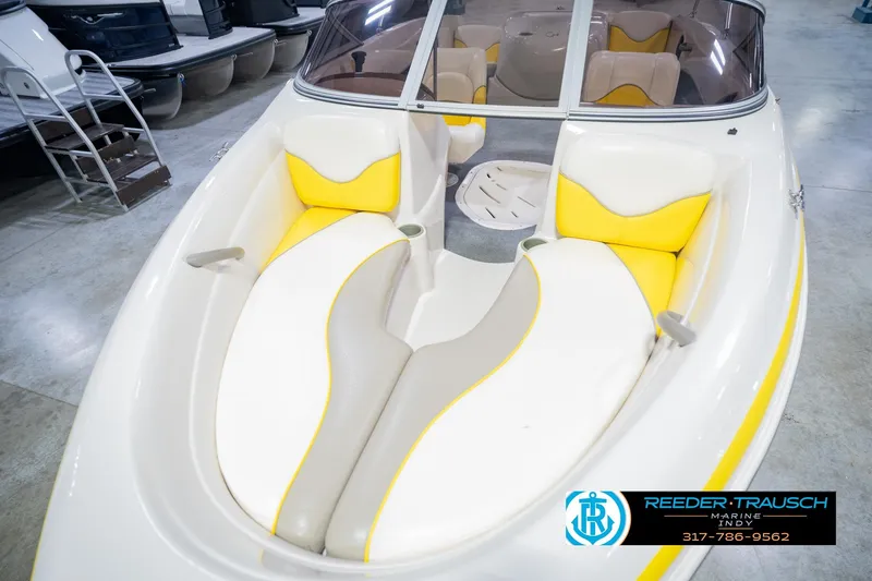 Slide: The Image of 2005 Tahoe Q4 boat interior with yellow and white seating, showcased in a showroom. - 12
