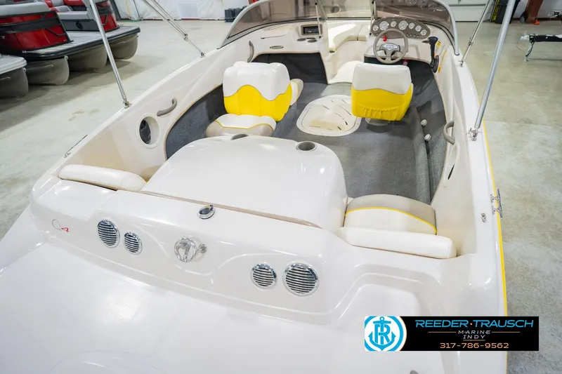 Slide: The Image of 2005 Tahoe Q4 boat interior with yellow and white seating, displayed in showroom. - 14