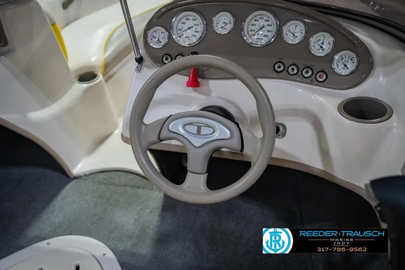 Slide: The Image of Steering wheel and dashboard of a 2005 Tahoe Q4 boat, featuring multiple gauges and controls. - 24
