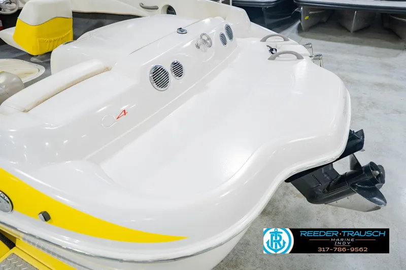 Slide: The Image of 2005 Tahoe Q4 boat with yellow accents and outboard motor in showroom. - 52