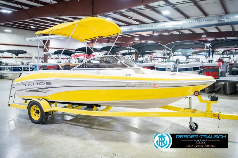 Slide: The Image of Yellow 2005 Tahoe Q4 boat with canopy on trailer in indoor showroom. - 6