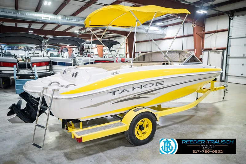 Slide: The Image of 2005 Tahoe Q4 boat with yellow accents on trailer in indoor showroom. - 8