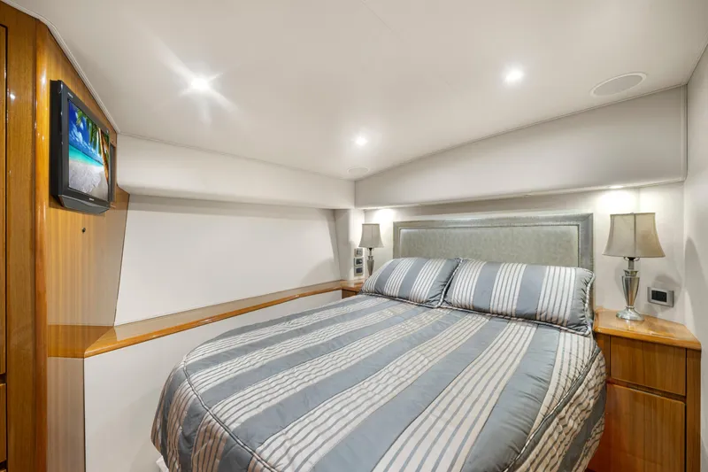 Slide: The Image of Luxurious bedroom interior of 2009 Viking 50 Convertible yacht with striped bedding and modern lighting. - 22