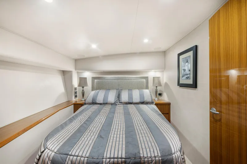 Slide: The Image of Luxurious bedroom interior of 2009 Viking 50 Convertible yacht with striped bedding and elegant decor. - 23
