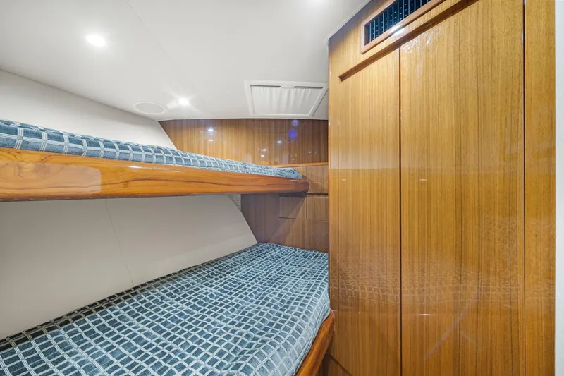 Slide: The Image of Interior of 2009 Viking 50 Convertible yacht with wooden bunk beds and blue checkered bedding. - 28