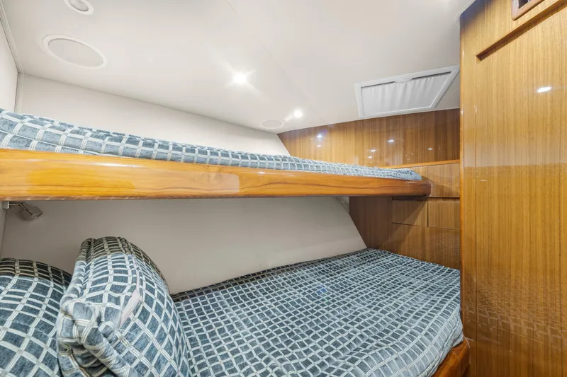 Slide: The Image of Interior of 2009 Viking 50 Convertible yacht with wooden bunk beds and patterned bedding. - 29