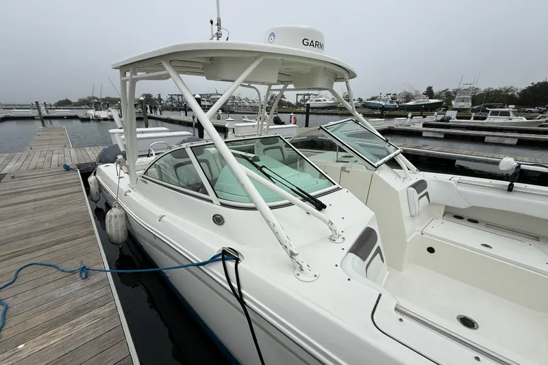 Slide: The Image of 2018 World Cat 295 DC boat docked at marina, featuring sleek design and spacious deck. - 5