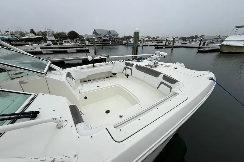 Slide: The Image of 2018 World Cat 295 DC boat docked at marina, showcasing spacious seating area. - 6