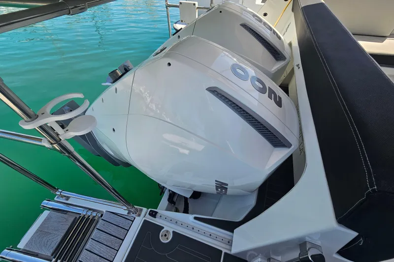 Slide: The Image of 2021 Jeanneau NC Weekender 895 with dual outboard motors on turquoise water. - 12
