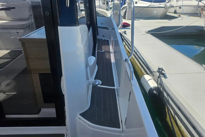 Slide: The Image of 2021 Jeanneau NC Weekender 895 docked, showcasing sleek side deck and modern design. - 13