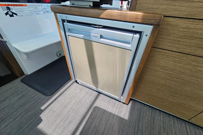 Slide: The Image of Compact fridge in 2021 Jeanneau NC Weekender 895 boat interior. - 23