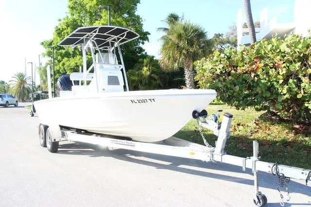 The Image of 2024 Pathfinder 2200 TRS boat on trailer, sunny day, palm trees in background. - 1