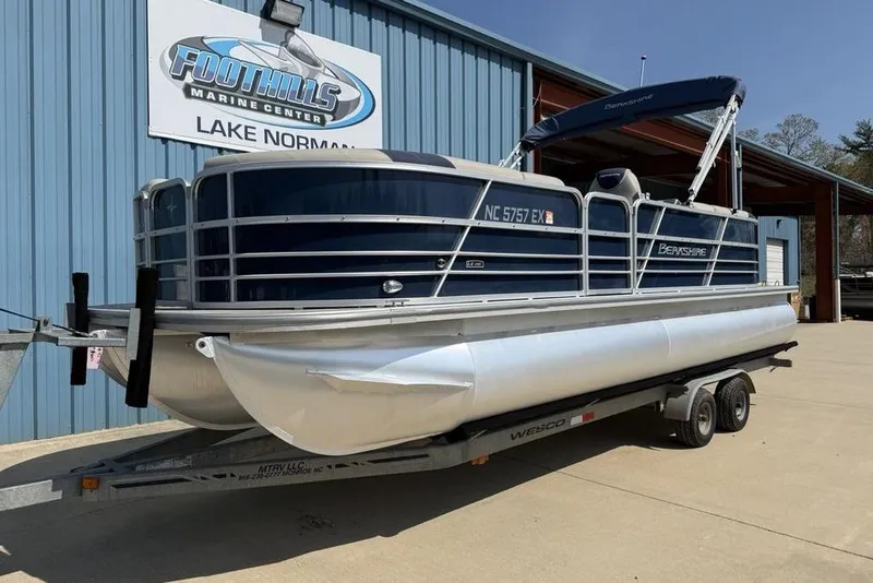 Slide: The Image of Captain's chair on 2022 Berkshire 24RFX LE pontoon boat, featuring beige and navy upholstery. - 12