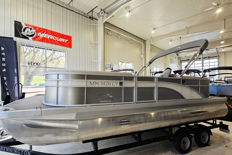 The Image of 2019 Bennington SX 22 Premium Stern Radius pontoon boat displayed indoors on a trailer. - 1
