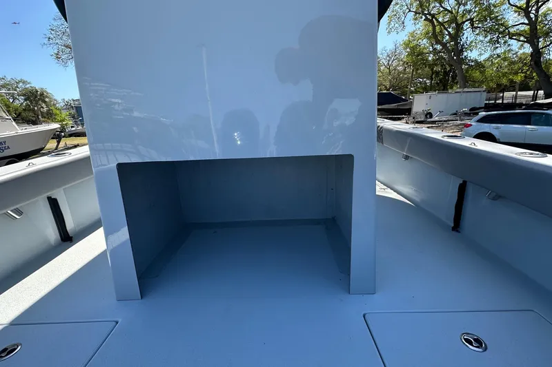 Slide: The Image of 2023 Latitude Tournament Boats LTB 25 with T-top and rod holders, parked outdoors. - 13