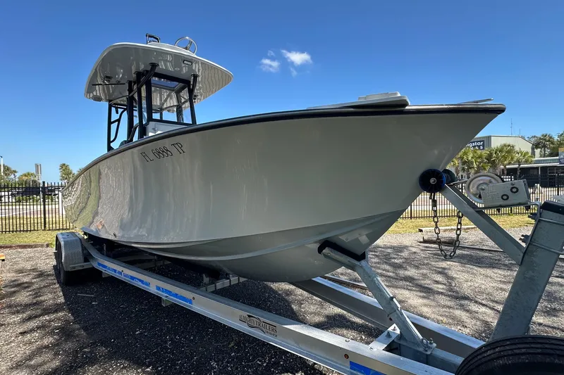 Slide: The Image of 2023 Latitude Tournament Boats LTB 25 on trailer, parked outdoors under clear blue sky. - 2