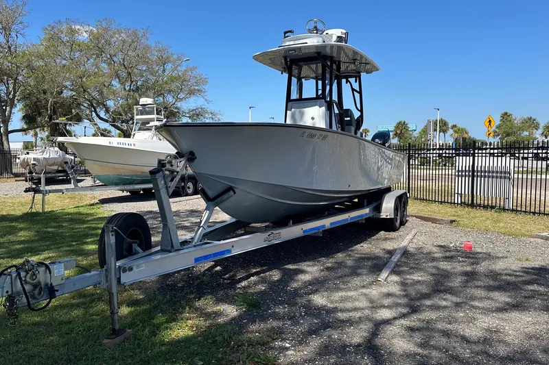 Slide: The Image of 2023 Latitude Tournament Boats LTB 25 on trailer, featuring dual Suzuki engines, parked outdoors. - 6
