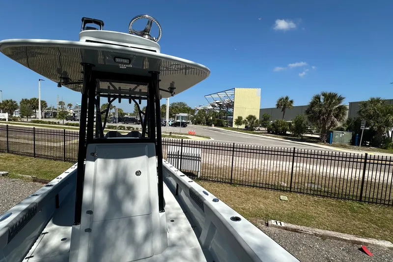Slide: The Image of 2023 Latitude Tournament Boats LTB 25 helm with steering wheel and controls under clear blue sky. - 9