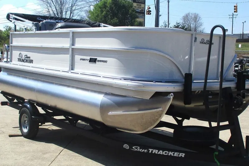 Slide: The Image of 2026 Sun Tracker Party Barge 18 DLX pontoon boat on trailer, parked outdoors. - 3