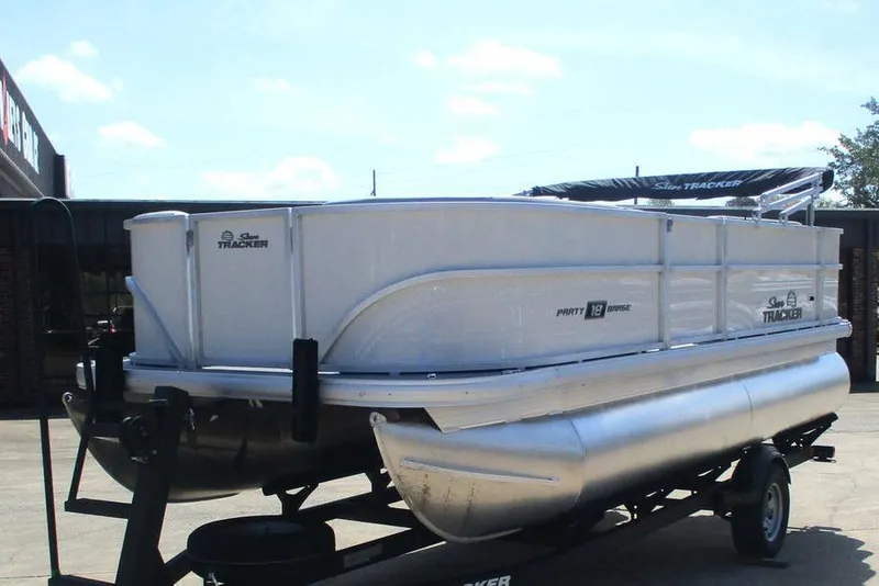 Slide: The Image of 2026 Sun Tracker Party Barge 18 DLX pontoon boat on trailer, parked outdoors. - 7
