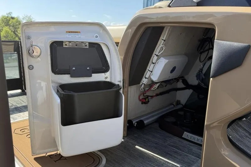 Slide: The Image of Interior view of 2026 Godfrey Monaco 235 SB boat storage compartment with wiring and storage bin. - 7