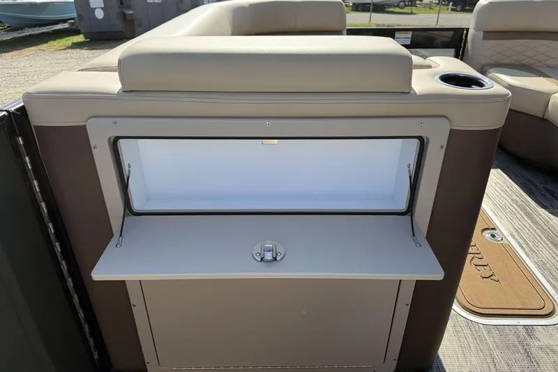 Slide: The Image of 2026 Godfrey Monaco 235 SB boat interior with open storage compartment and cup holder. - 8